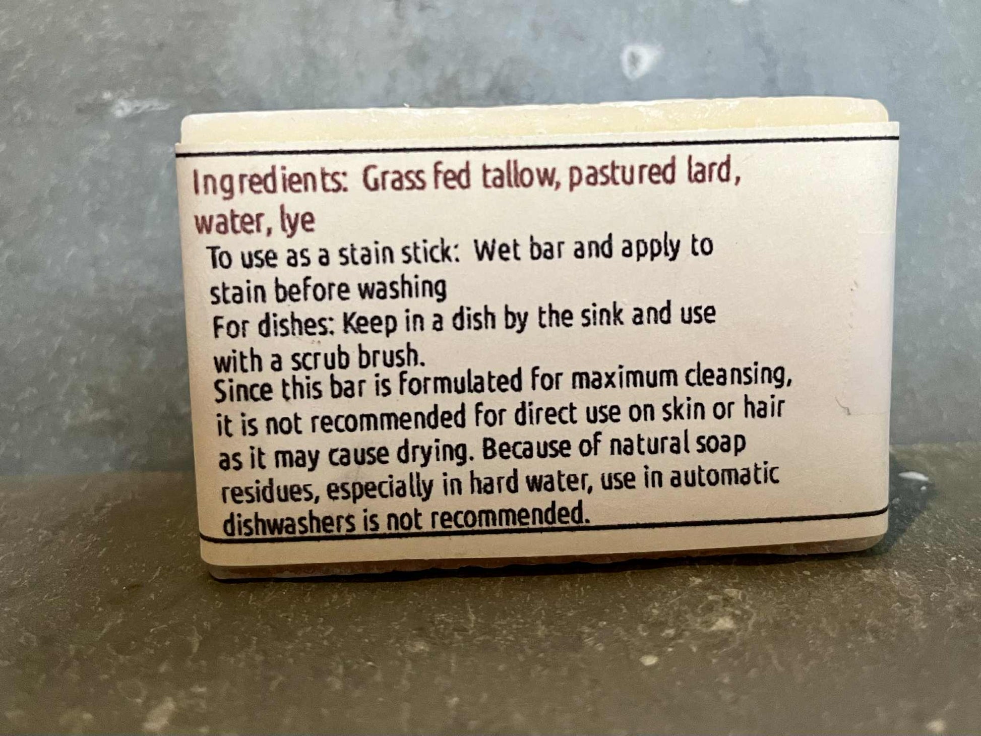 a bar of solid dish soap made with tallow and lard, showing a label with instructions for use
