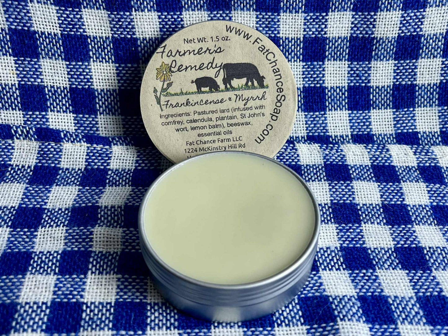 an open tin of herbal lard salve