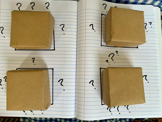 four bars of soap wrapped in brown paper surrounded by question marks