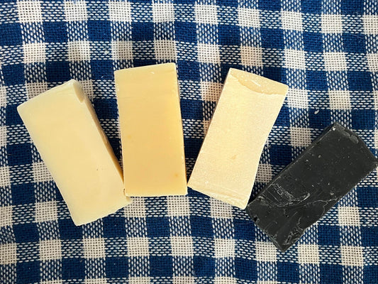 four small blocks of tallow and lard soap in different colors