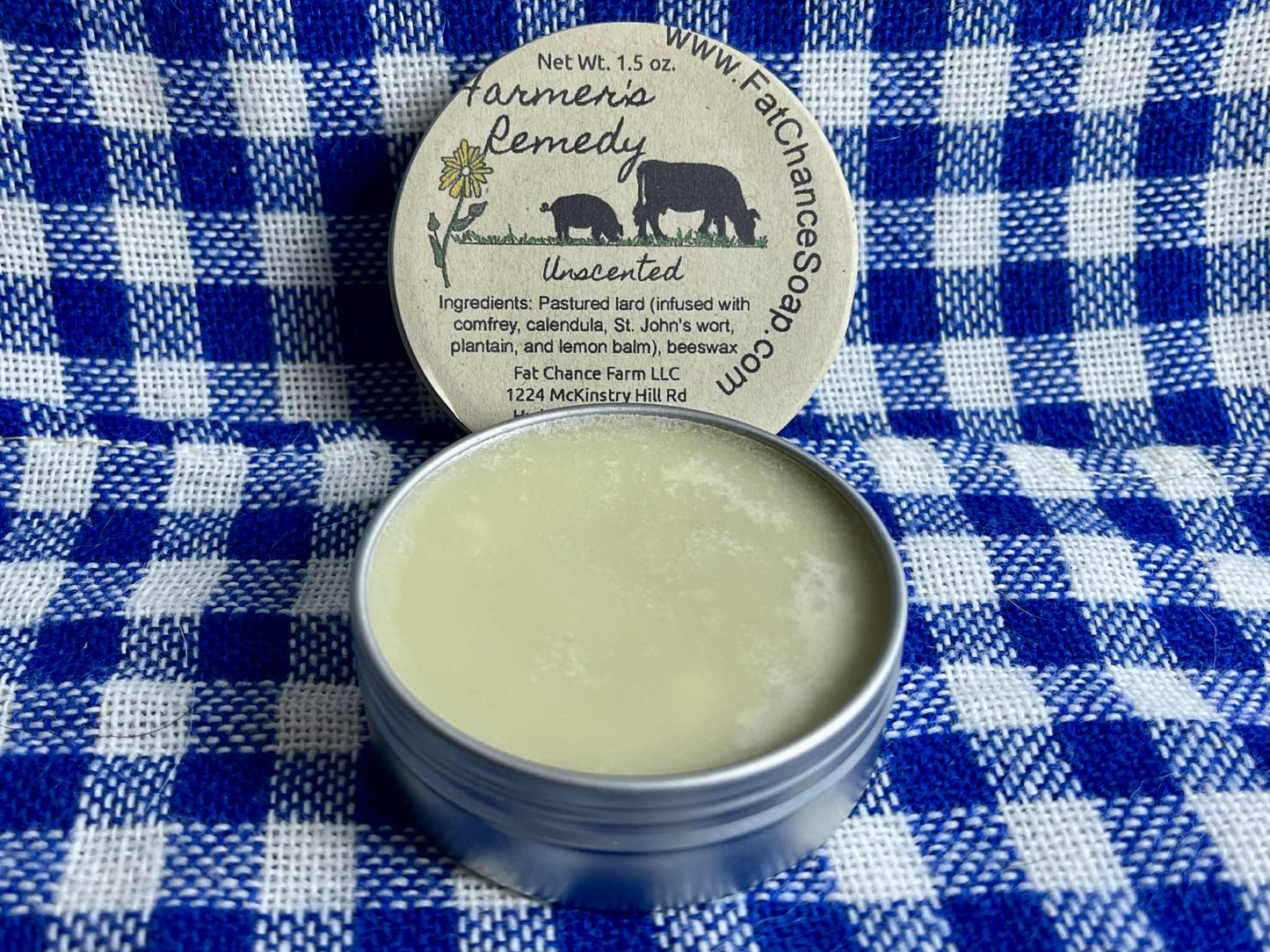 an open tin of herbal lard salve